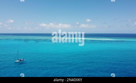 Aerila a tiré d'un bateau à voile à Anchot avec un petit cay sany et un récif de fringing derrière Banque D'Images