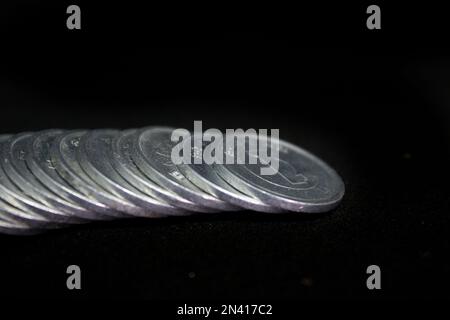 Pile de pièces d'un yen isolée sur fond noir. Banque D'Images