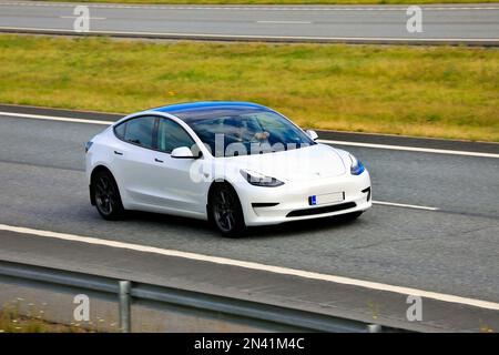 Voiture électrique White Tesla modèle 3 à grande vitesse sur autoroute. Salo, Finlande. 9 juillet 2021. Banque D'Images