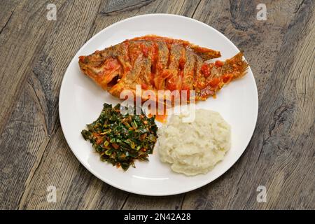 Ragoût de tilapia, ugali (purée de farine de maïs blanc) et Sukuma Wiki (ragoût de kale), nourriture kenyane Banque D'Images