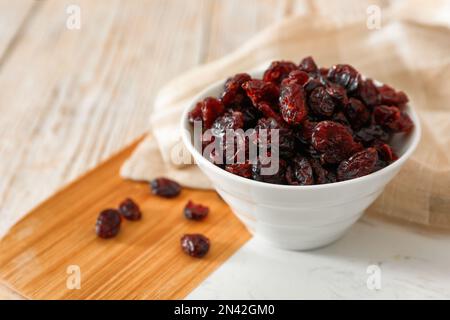 Canneberges séchées dans un bol sur une table légère, gros plan Banque D'Images