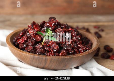 Canneberges séchées dans un bol sur une table en bois, en gros plan Banque D'Images