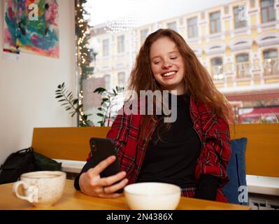 Amis multiraciaux filles et les gars ayant le plaisir de rire en buvant le thé de café dans le café, heureux divers jeunes plaisantant parler assis ensemble Banque D'Images