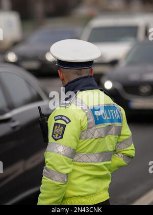 Bucarest, Roumanie - 8 février 2023 : agent de police routière roumain dans le centre-ville de Bucarest pendant les heures de pointe. Banque D'Images