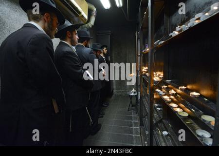 Prières après avoir allumé Chanukkah une menorah dans une petite pièce à l'Ohel, à côté des têtes des 2 derniers Lubavitcher Rebbes. À Queens, New York. Banque D'Images