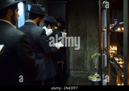 Prières après avoir allumé une menorah de Chanukkah dans une petite pièce à l'Ohel, à côté des têtes des 2 derniers Rebbes de Lubavitcher. À Queens, New York. Banque D'Images