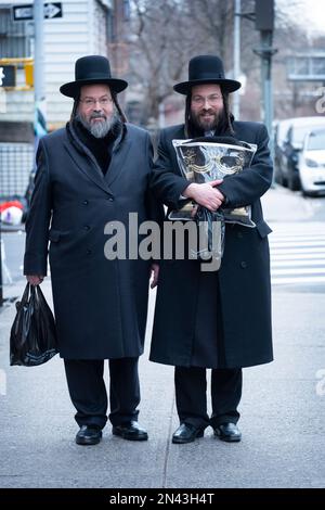 Portrait posé de père juif orthodoxe et de son fils. chacune est vêtue de noir et avec un peyot long et bouclé. À Williamsburg, Brooklyn, New York. Banque D'Images