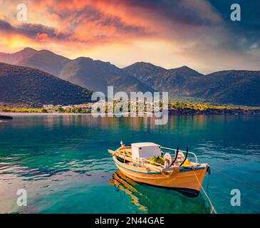 Lever de soleil coloré dans le port de Logari avec petit bateau de pêche avec village de Kyparissi en arrière-plan. Pittoresque scène estivale de la péninsule du Péloponnèse, Greec Banque D'Images