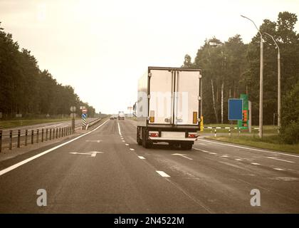 Un camion à semi-remorque blanche transporte du fret sur une autoroute. Le camionnage en tant qu'entreprise, industrie. Banque D'Images