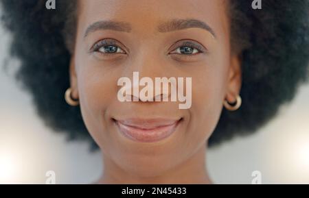 Portrait jeune femme noire souriante. Visage de femme ou d'étudiant afro-américain drôle, gai, magnifique et edgy avec afro debout à l'intérieur contre Banque D'Images