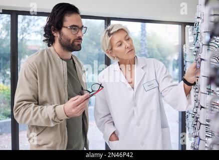 Optométriste aider le client avec le choix de lunettes, de vision et de lentilles en magasin. Opticien, nouveaux cadres et étagère de lunettes pour le soin des yeux, conseil Banque D'Images