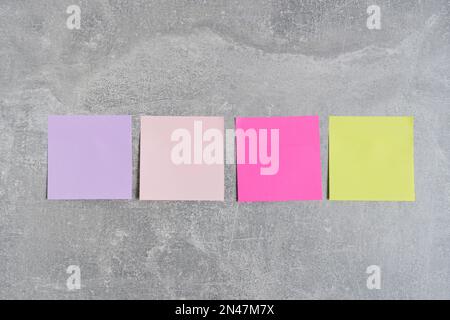 Les autocollants colorés pour écrire des notes sont des murs de béton collés Banque D'Images