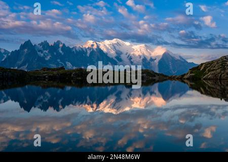 Les sommets du massif du Mont blanc et quelques nuages, qui réfléchissent au lever du soleil sur la surface des Lacs des Chéserys, une tente installée sur une crête. Banque D'Images