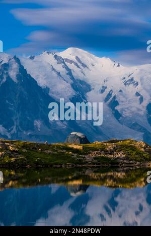 Les sommets du massif du Mont blanc et quelques nuages, qui réfléchissent au lever du soleil sur la surface des Lacs des Chéserys, une tente installée sur une crête. Banque D'Images