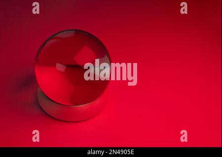 Boule de cristal de verre sur une table avec lumière rouge Banque D'Images