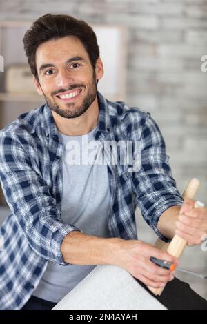 happy man rembourrer un tabouret rond Banque D'Images