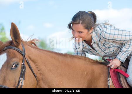 Femme à cheval, penchée vers l'avant