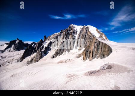 Vue sur les pistes et les crevasses de la partie supérieure du glacier géant, les falaises rocheuses et le sommet du Mont blanc du Tacul au loin. Banque D'Images