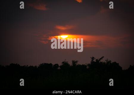 Le soleil d'or s'enfonce dans le ciel du village du Bangladesh. C'est la scène en été. Banque D'Images