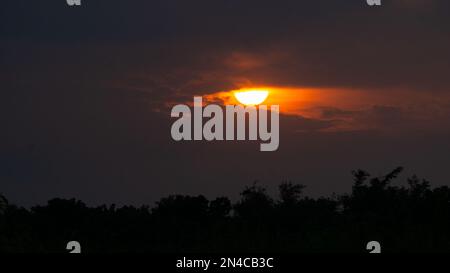 Le soleil d'or s'enfonce dans le ciel du village du Bangladesh. C'est la scène en été. Banque D'Images