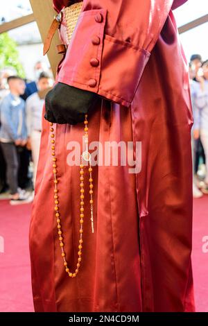 Arahal. Séville. Espagne. 14 avril 2022. Détail d'une main avec un rosaire d'un pénitent de la fraternité de la Misericordia, Arahal (Séville), pendant t Banque D'Images