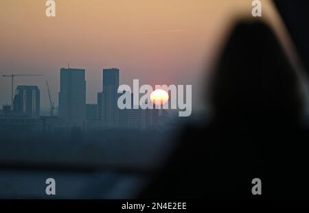 Berlin, Allemagne. 08th févr. 2023. Une femme observe le soleil couchant depuis le dôme du bâtiment du Reichstag. Credit: Philipp Znidar/dpa/Alamy Live News Banque D'Images