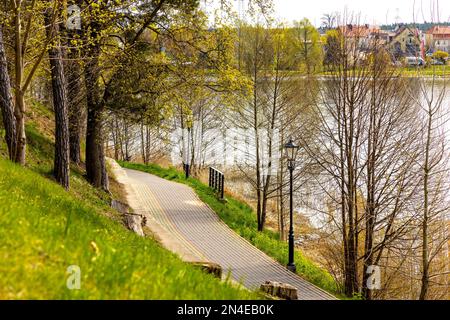 Elk, Pologne - 1 mai 2022 : promenade touristique le long du lac Jezioro Elckie rive boisée au printemps ville d'Elk de la région de Masuria en Pologne Banque D'Images