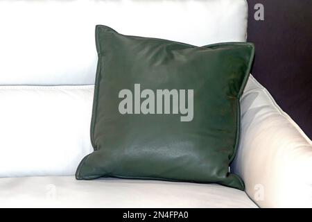 Coussin décoratif en cuir vert dans le coin du canapé blanc Banque D'Images