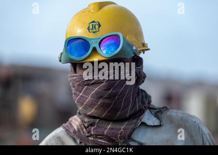 Gadani Pakistan août 2021, portrait d'un travailleur portant un casque de sécurité jaune debout sur l'épave du navire à la cour de cassation du navire Gadani. Banque D'Images