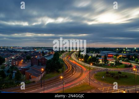 Une longue exposition de la circulation près d'un rond-point pendant Twilight à Ashton sous Lyne, Manchester, Royaume-Uni. Banque D'Images