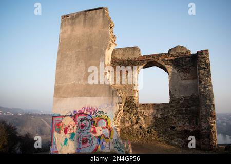 Ruines cassées de la vieille maison sur la roche couverte par des panneaux vandales à la lumière du soir. ruines de baba dans la périphérie de Prague. Banque D'Images