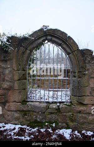 Falkenstein, Allemagne - 31 janvier 2021: Fenêtre avec grille sur les ruines du château de Falkenstein en Rhénanie Palatinat, Allemagne, lors d'une journée d'hiver enneigée. Banque D'Images