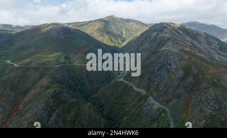 Photo aérienne d'une autoroute passant le long de la pente verte de la chaîne de montagnes Banque D'Images