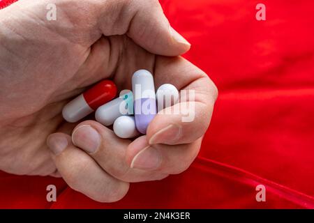 l'homme tient beaucoup de capsules de pilule colorées dans ses paumes Banque D'Images