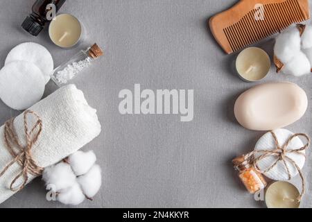 Accessoires de spa et cosmétiques sur fond de texture grise. Serviette, savon, brosse à cheveux, huile essentielle. Produits de bien-être écologiques naturels, sans gaspillage. C Banque D'Images