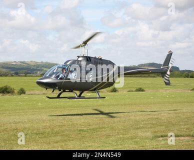 Un hélicoptère Agusta-Bell AB-206A JetRanger vole le long de la piste d'un aérodrome de East Sussex Banque D'Images