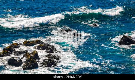 Belles rochers falaises pierres et rochers et énormes grandes vagues de surfeurs et vue panoramique naturelle sur la plage de Bacocho Puerto Escondido Oaxaca Mexique. Banque D'Images