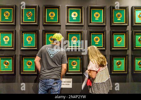 Couple regarde le mur des Elvis Gold Records dans le Memphis Entertainment Complex d'Elvis Presley à Graceland à Memphis, Tennessee. Banque D'Images