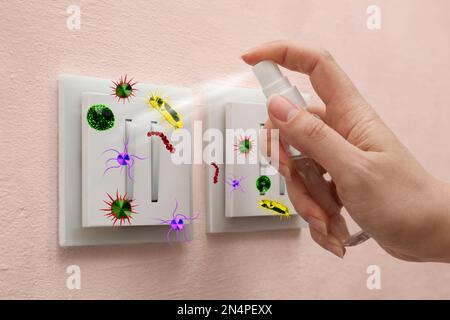 Femme pulvérisant un antiseptique sur un interrupteur lumineux plein de microbes, gros plan Banque D'Images