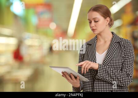 Inspecteur avec tablette dans le centre commercial, espace pour le texte. Contrôle qualité Banque D'Images