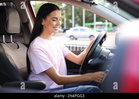 Jeune femme au démarrage du moteur de la voiture. École de conduite Banque D'Images