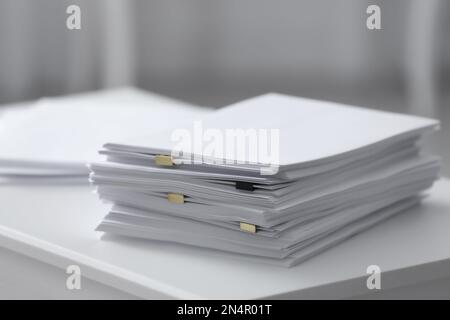 Pile de papier vierge sur table blanche Banque D'Images