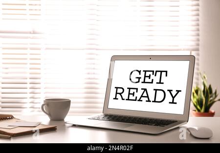 Ordinateur portable moderne avec phrase Get Ready à l'écran au bureau Banque D'Images