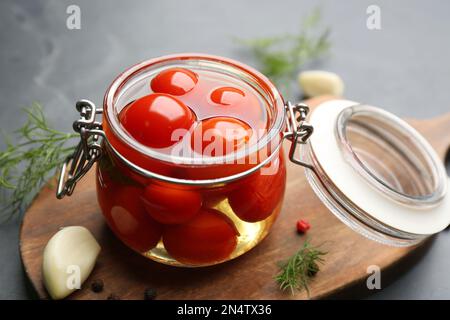 Pot en verre de tomates cerises marinées sur bois, gros plan Banque D'Images