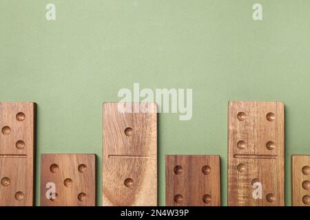 Carreaux Domino en bois sur fond vert, plat. Espace pour le texte Banque D'Images