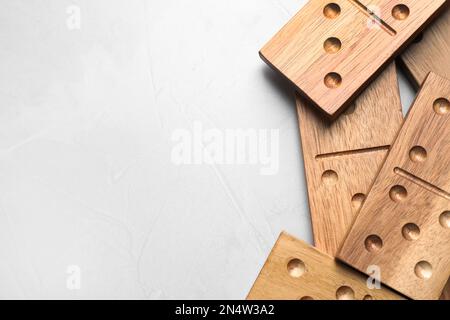 Carreaux Domino en bois sur table gris clair, plat. Espace pour le texte Banque D'Images