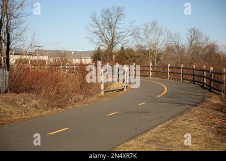 Piste cyclable au coucher du soleil sur une longue route Banque D'Images