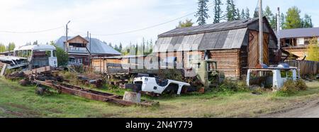 De nombreux bâtiments en fer abandonnés de voitures se trouvent dans le village nord de Yakutia, dans une décharge parmi les maisons résidentielles en bois. Banque D'Images