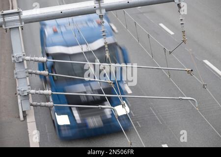 PRODUCTION - 01 février 2023, Hesse, Weiterstadt: Un camion conduit sur le A5 sous les pylônes de l'autoroute E. Près de quatre ans après l'ouverture de la première autoroute électrique allemande pour les camions hybrides sur le A5 à Hesse, la responsable Autobahn GmbH a tiré un bilan intermédiaire positif. (À dpa 'solde provisoire positif pour l'autoroute E à Hesse') photo: Sebastian Gollnow/dpa Banque D'Images