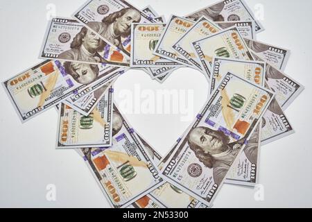 pour l'amour de l'argent coeur de forme cent billets de dollars sur fond blanc Banque D'Images